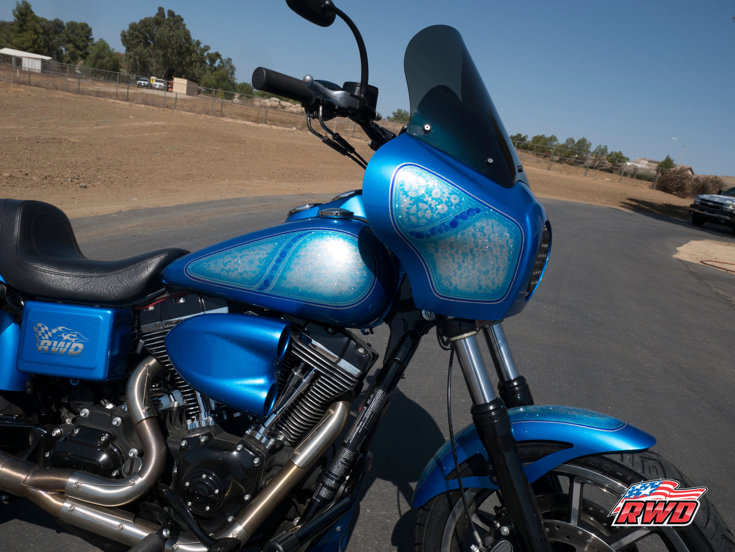 RWD V-Twin parts installed on a custom blue Harley parked on pavement
