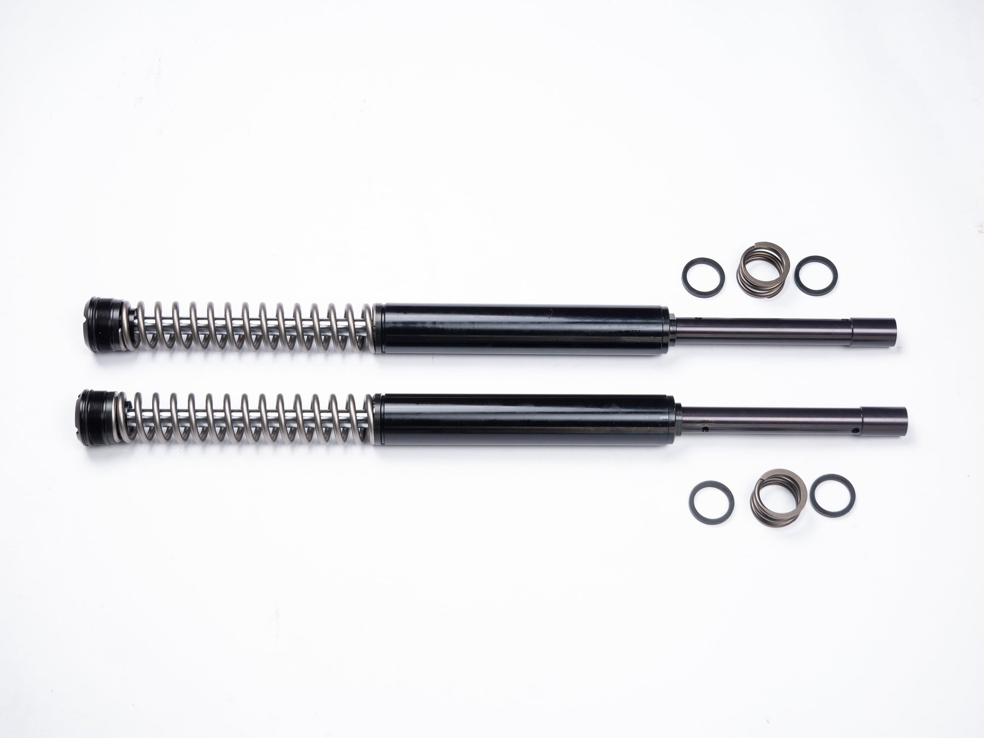 Parts of the RWD RS-1F softail front fork cartridge system laid out on a white background